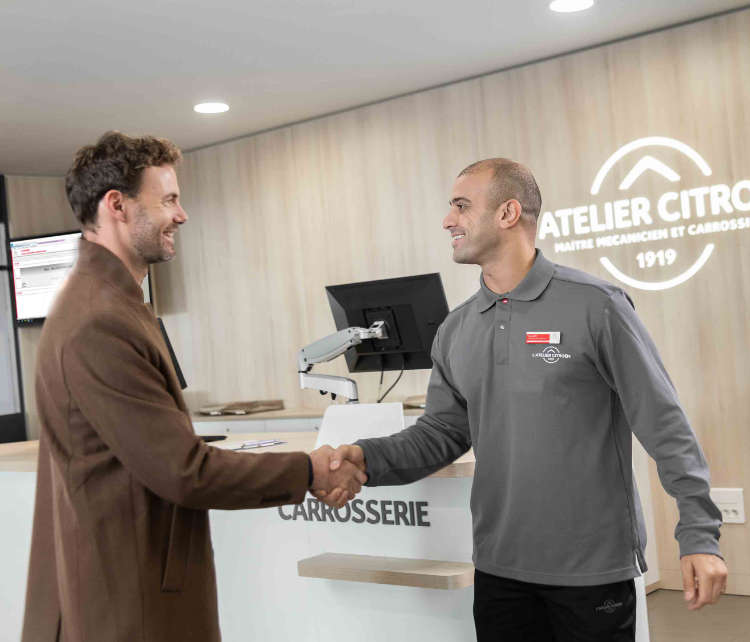 Клієнт і сервісний консультант вітаються на СТО