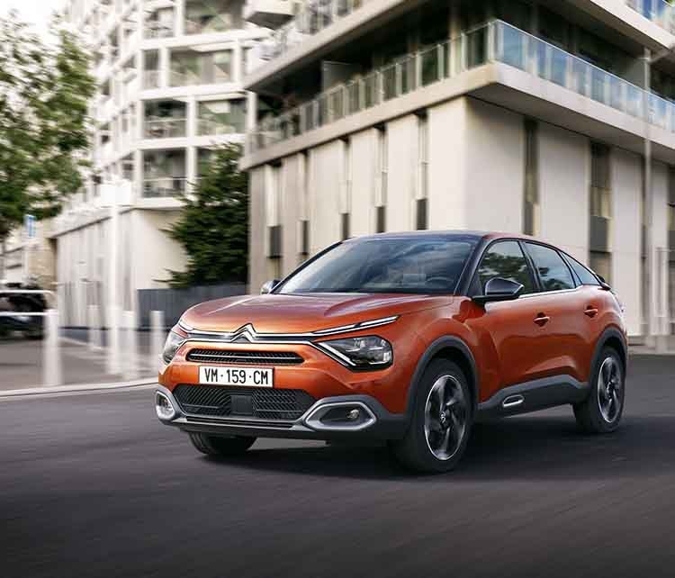 Citroen C4 оранжевого кольору, вигляд спереду з лівого боку