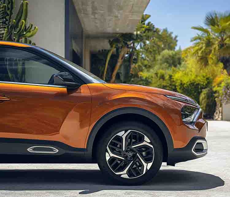 Передня частина Citroen C4 оранжевого кольору, вигляд з правого боку