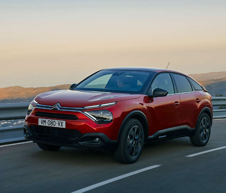 Citroen C4 їде по трасі, вигляд спереду з лівого боку